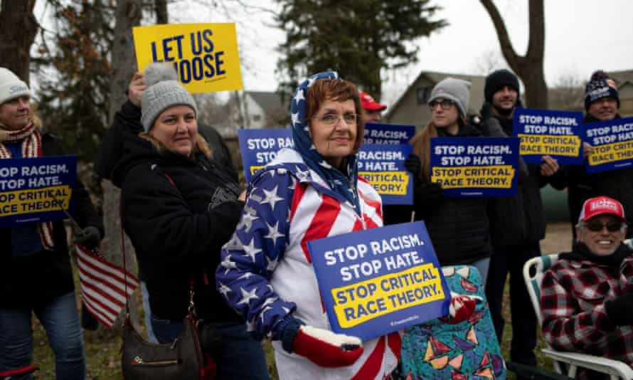 Protesters hold posters regarding critical race theory in the Brandon Township village of Ortonville, Michigan, in November 2021.