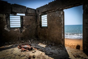 A child sleeps on the floor of his house about to collapse, destroyed by coastal erosion on Afidegnigba beach, Togo, West Africa
