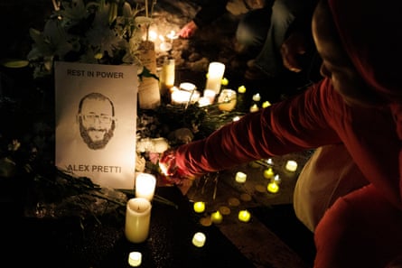 A person places a candle at a memorial