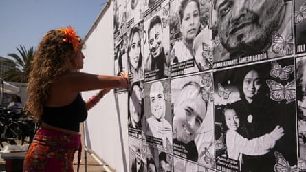 Woman in front of large panel with photographs of people