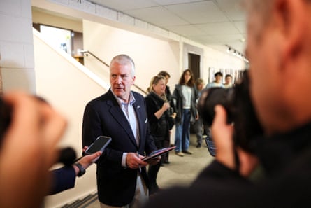 An older man speaks to reporters