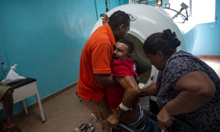 Paralyzed by decompression sickness, lobster diver Misael Banegas Díaz, 49, is lifted by physical therapist Cedrak Waldan Mendoza into a hyperbaric chamber at the hospital in Puerto Lempira.