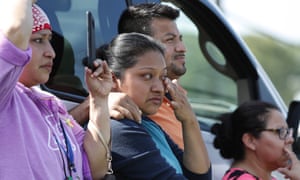 Friends, coworkers and family watch as US immigration officials raid the Koch Foods Inc plant in Morton, Mississippi, on Wednesday.