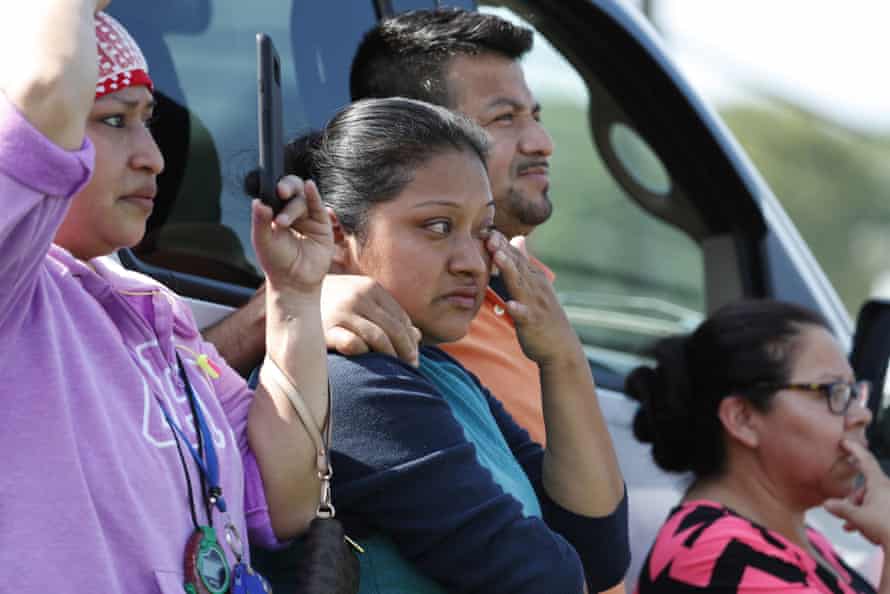 Friends, coworkers and family watch as US immigration officials raid a Koch Foods plant in Morton.