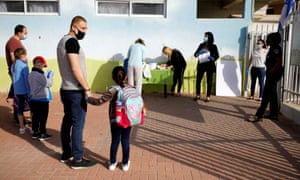 Parents wait with their children to enter their elementary school in Sderot as it reopens in Israel 3 May, 2020.