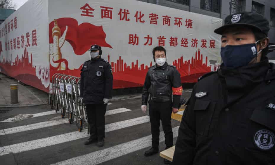 Security guards control access to a residential area of Beijing, China, on Thursday to help fight the spread of coronavirus.