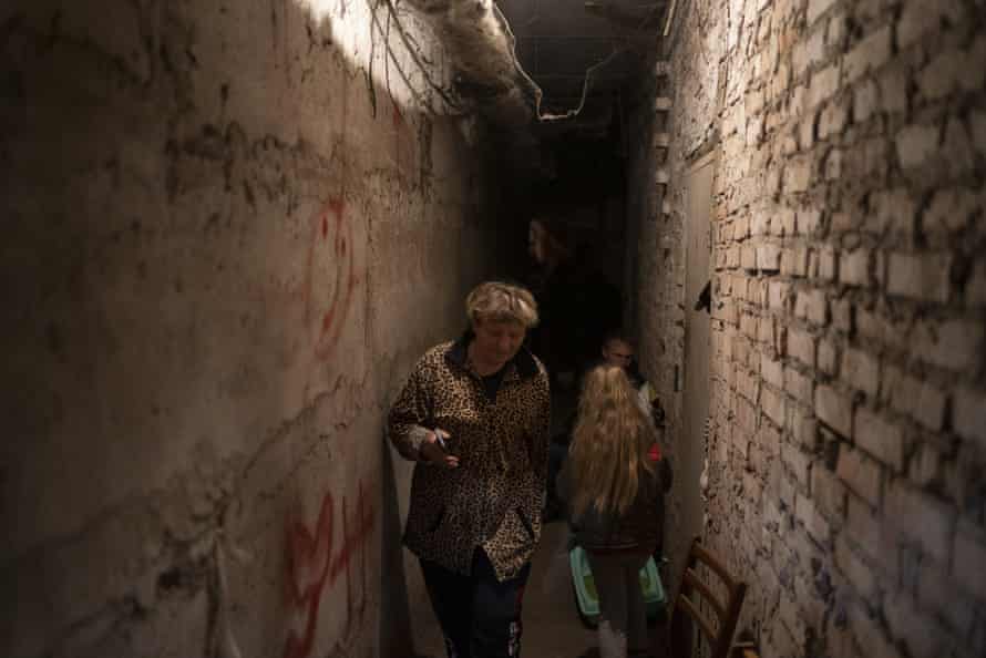 A woman walks inside the basement of a residential building during a Russian attack in Lyman, Ukraine.