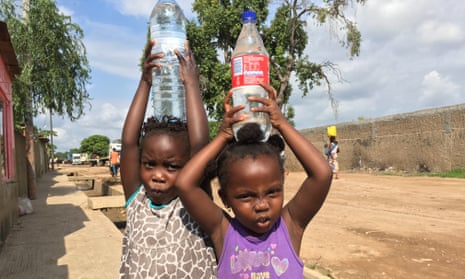 Girls carry bottled water in Maputo, where a drought has reversed progress in improving access to water.