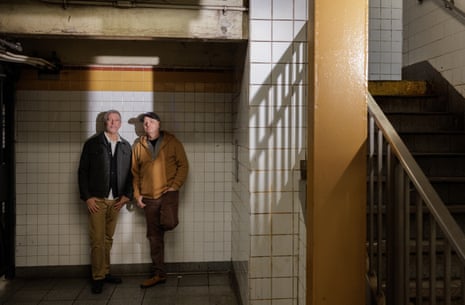 Danny and Pete standing against a white tiled wall in a subway in New York