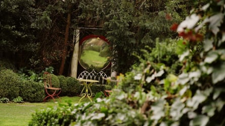 A green lawn and iron garden furniture.