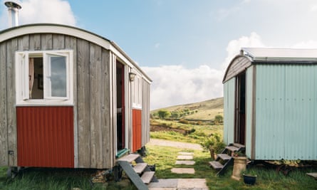 Two rustic cabins made of wood and corrugated metal