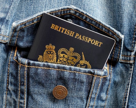 A blue British passport tucked inside a denim jacket pocket