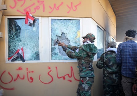 Members the Hashed al-Shaabi, a mostly Shiite network of local armed groups trained and armed by powerful neighbour Iran, smash the bullet-proof glass of the US embassy’s windows in Baghdad.