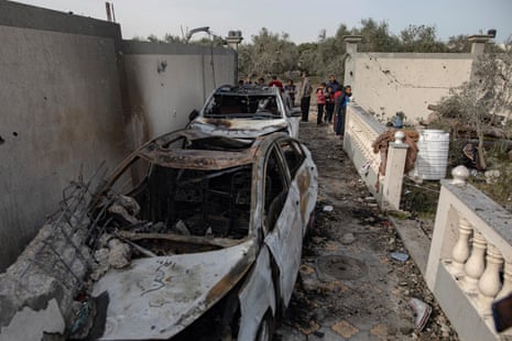 Palestinian inspect vehicles and a house damaged after an Israeli air strike in the Rafah refugee camp, southern Gaza Strip, 26 March 2024.