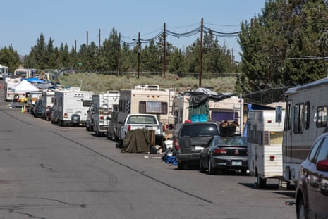 A line of parked RVs and other vehicles on the side of a highway.