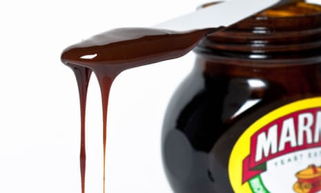 Knife with dripping marmite on top of a jar