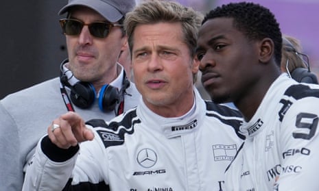 Brad Pitt, kiri, berbicara dengan aktor Damson Idris di grid sebelum Grand Prix Formula Satu Inggris.