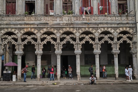 People stand under the colonnade of a Moorish-style building with the name Palacio de las Ursulinas carved into the stone