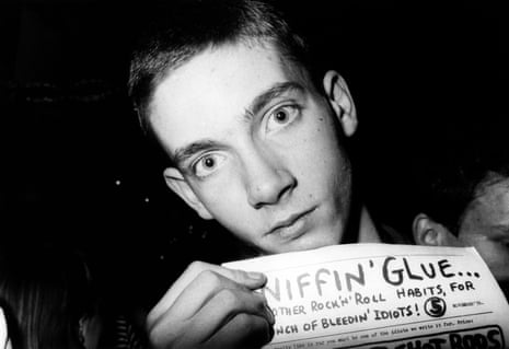 A young man holding a copy of the Sniffin' Glue fanzine