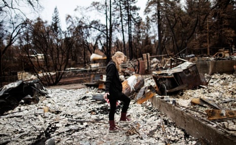 Ruth McLarty sifts through the remains of her destroyed home in Paradise, California.
