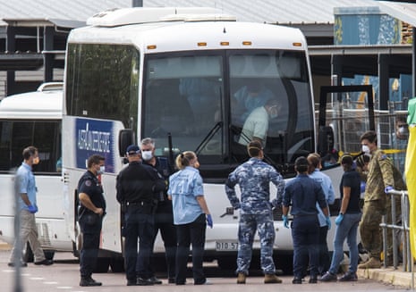 Government agencies gather beside buses to be used to take evacuees to a quarantine facility after arriving in Darwin from the cruise ship Diamond Princess in Japan. 