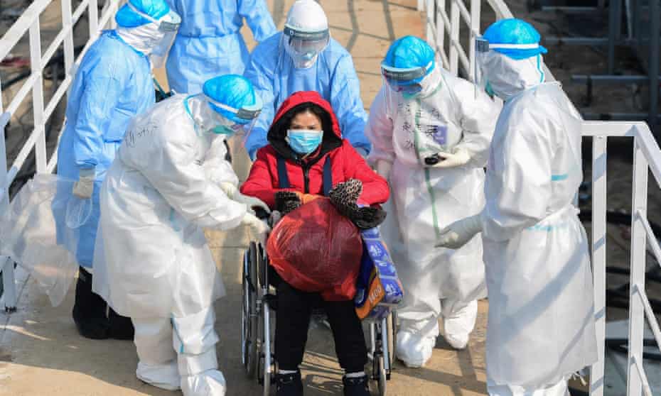 Medical workers with a patient at the new hospital in Wuhan, China, February 2020