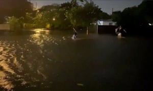 People walk in floodwaters caused by Storm Eta in Fort Lauderdale.