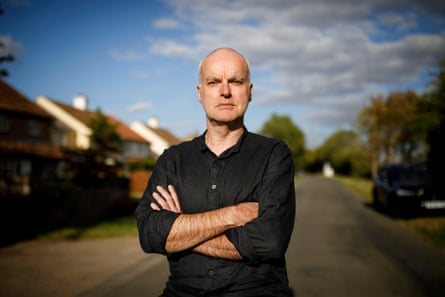 Wearing a black shirt, Robin Smith stands in the road with his arms crossed