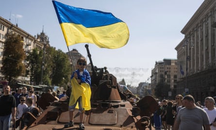 A boy waves a national flag in the centre of Kyiv