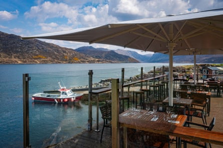 Decked outdoor dining area giving straight on to the lake