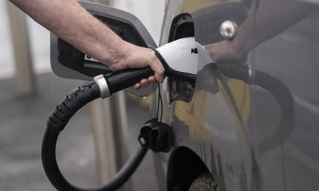 Person plugging charger into electric car