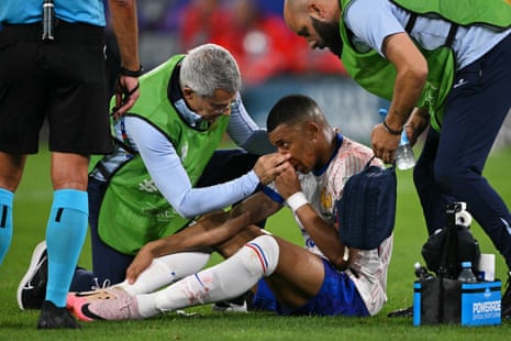 Kylian Mbappé receives medical treatment after his injury.