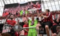 Bayer Leverkusen's goalkeeper Lukas Hradecky celebrates with the Bundesliga trophy among the fans.