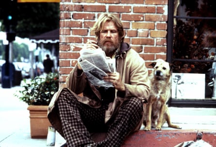 man sits outside on street corner while holding newspaper with dog next to him