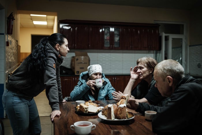 Evgenia, wife of chaplain Oleg, talks with evacuees after their arrival at a charity centre in Pokrovske, eastern Ukraine.