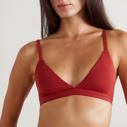 A model wears a dark red Skims triangle bralette