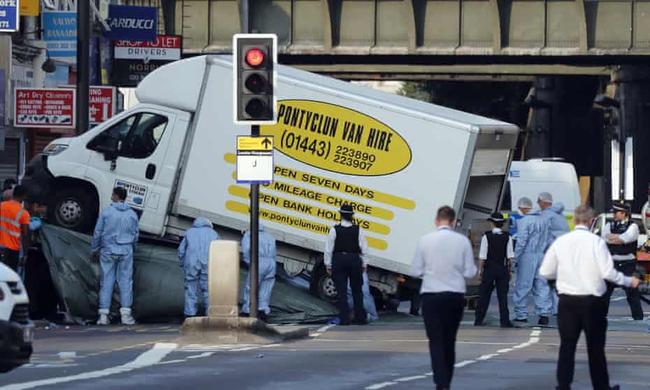 Forensic officers move the van that struck pedestrians near a mosque in Finsbury Park