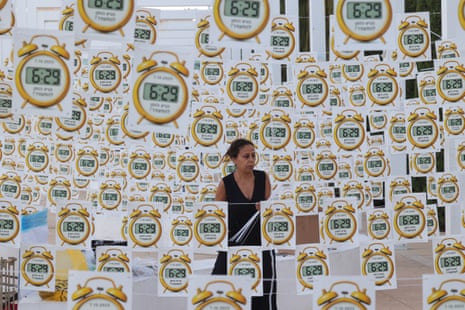 A woman stands among dozens of signs hanging at the square.