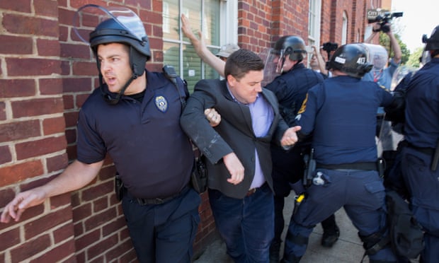 Police escort Jason Kessler after a press conference at city hall in Charlottesville, Virginia on 13 August 2017.