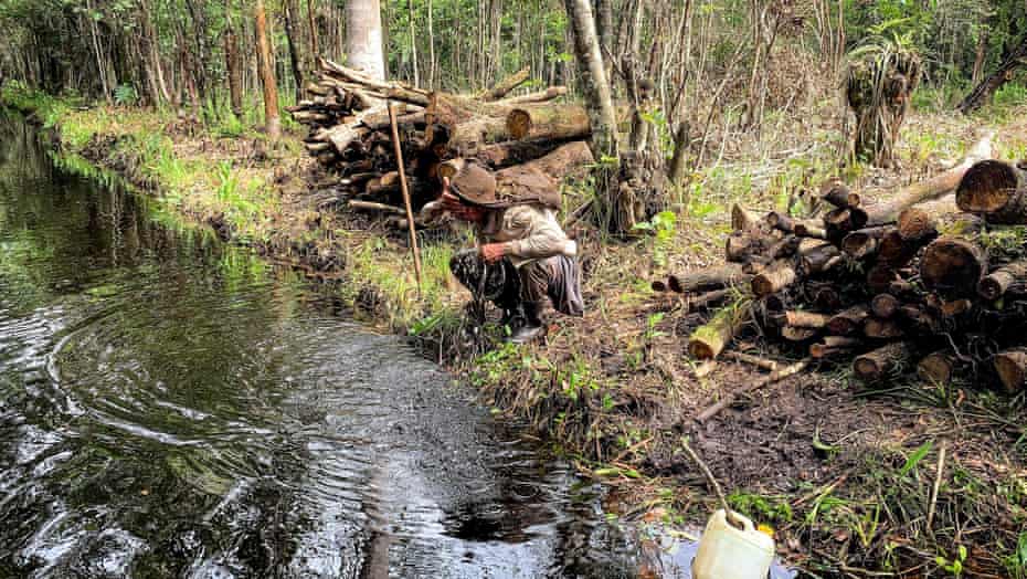 Charcoal producer Yunier Arista refreshes with water from a stream