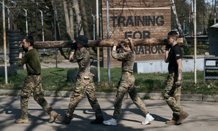 Four young recruits carry a log
