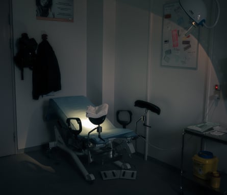A couch for gynaecological inspections lit by a spotlight in a dimly lit office