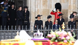 Royals look at the coffin of Queen Elizabeth II, draped in a royal standard and adorned with the imperial state crown and the sovereign’s orb and sceptre, as they leave Westminster Abbey