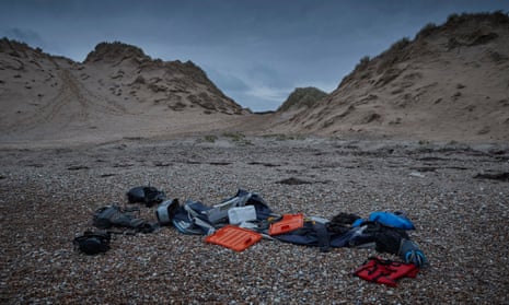 People’s belongings, along with a deflated dinghy, life jacket and engines, lie on a beach in Wimereux, near Calais, the morning after the drownings
