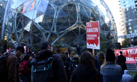 People gather with “Tax Amazon” signs in front of the Amazon Spheres in Seattle before the city council vote on Monday.