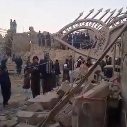 People gather near rubble in the aftermath of Pakistan’s military strike