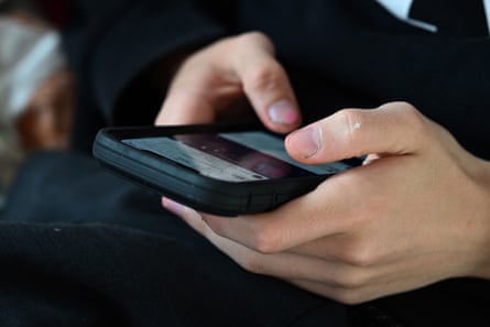 A teenager uses his mobile phone to access social media