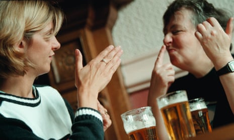 People in a pub drinking and using sign language.