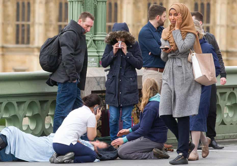A second photo (above) shows the woman visibly distressed as she passes the scene of the attack on Westminster Bridge.