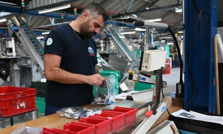 A worker checking packaging on the Meccano production line.